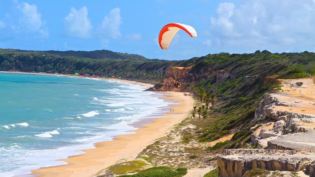 Praia de Pipa com falésias e parapente